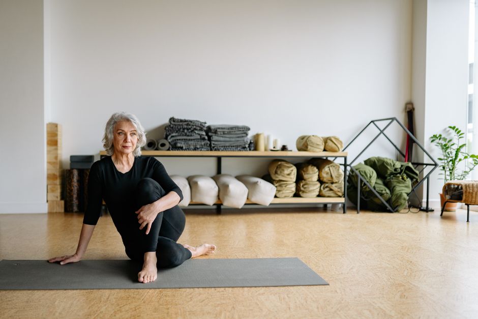 A seated yin yoga pose supported by a bolster